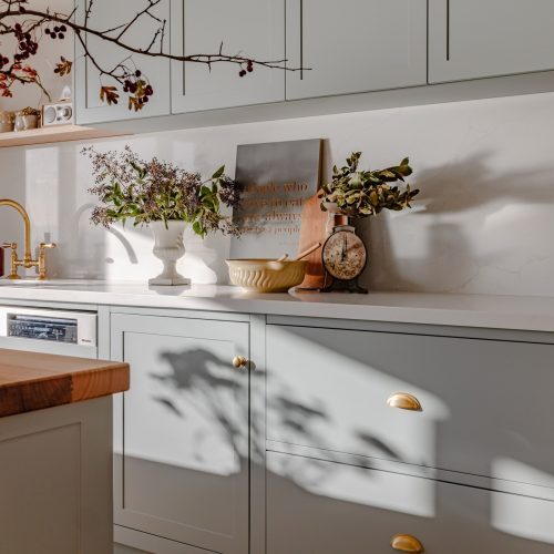 Morning light across sprayed sage drawer fronts and brass tapware, Blackmans Bay