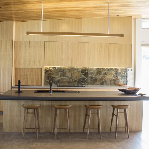 Pontypool kitchen island in clear finished timber with a stone splashback