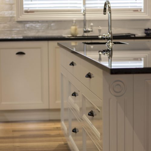 White shaker kitchen island with a dark benchtop, spray finished for a Cygnet home