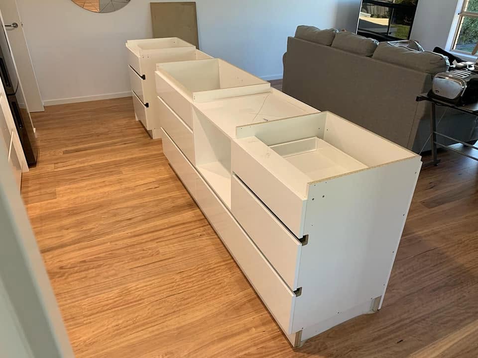 Sprayed cabinet carcasses and drawer fronts staged before installation