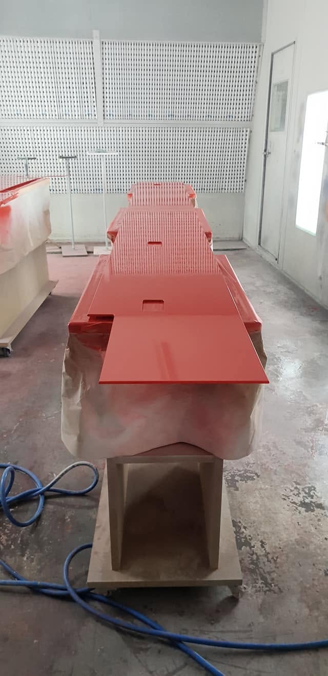 High-gloss red two-pack colour sprayed onto joinery panels in the spray booth