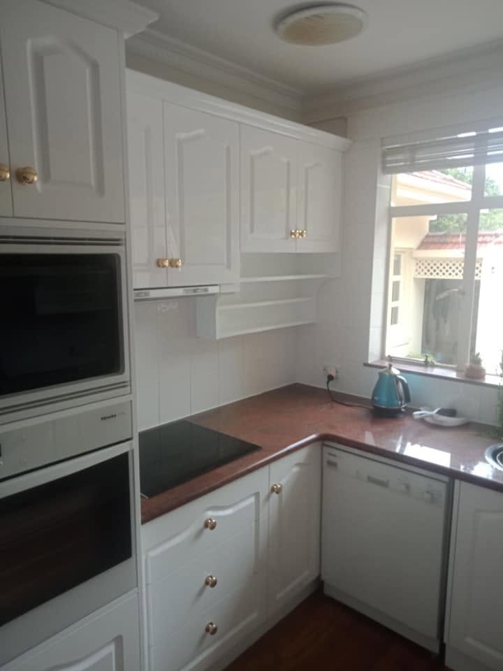 Refinished shaker cabinet doors resprayed in a clean white satin finish