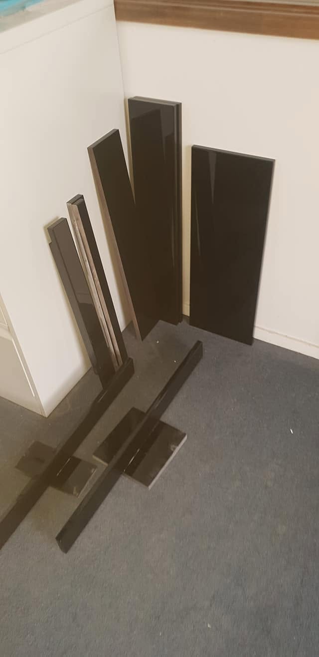 Dark sprayed joinery panels standing against the workshop wall to cure