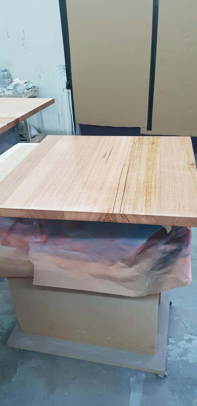 Solid timber benchtop laid out on the workshop bench between coats