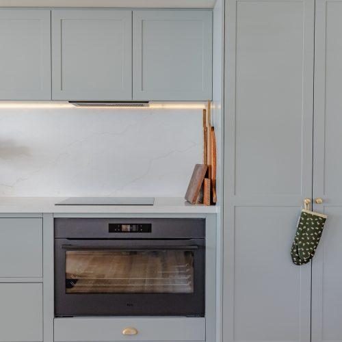 Sage green sprayed cabinetry framing the wall oven in a Blackmans Bay kitchen